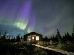 Un chalet la nuit d'un aurore boréale à la Baie-James