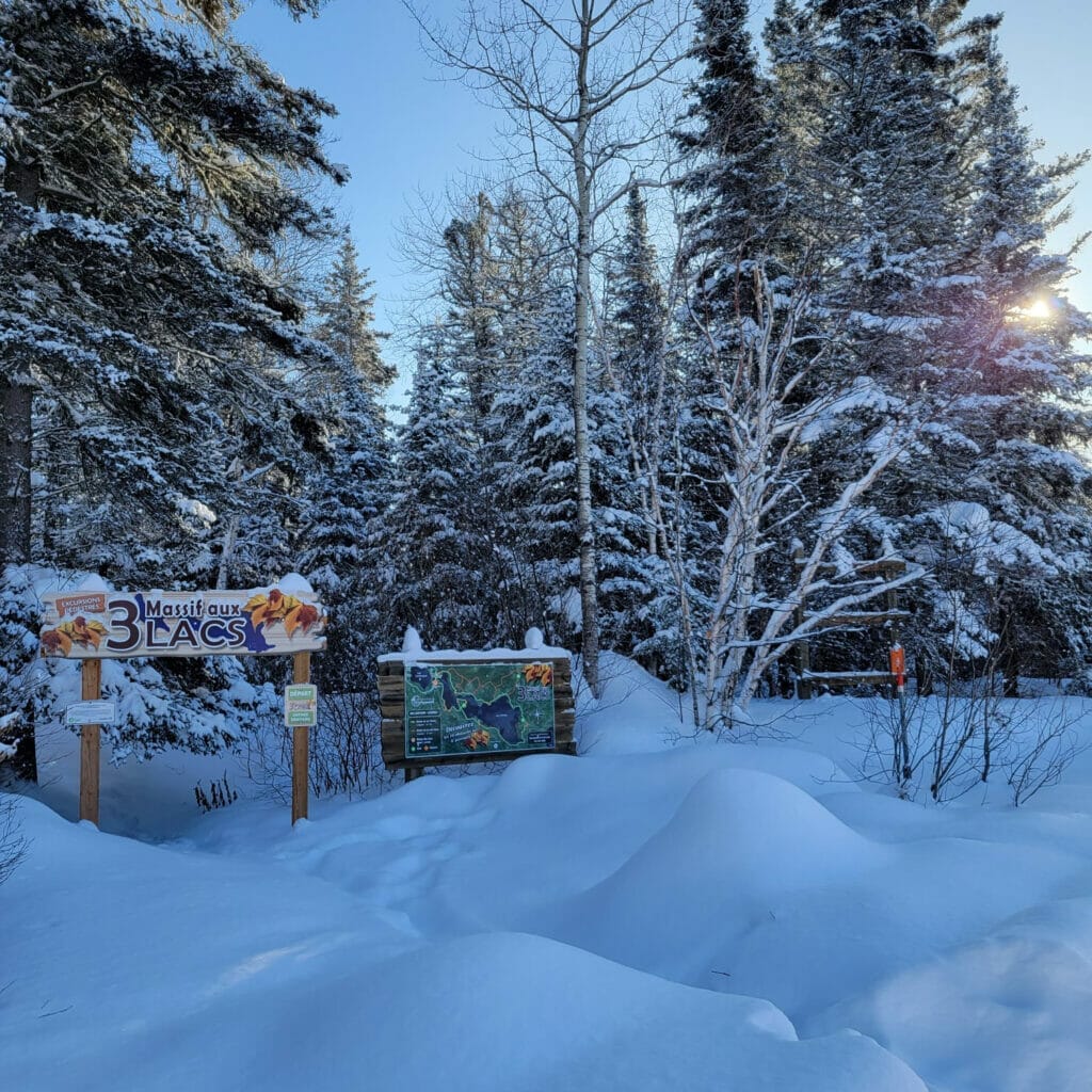 View of the signs at the Massif aux 3 Lac trailhead in Labrecque