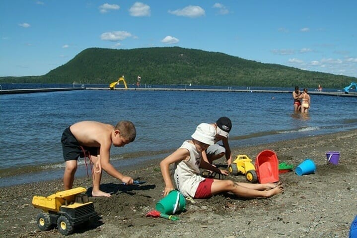 Children playing in the sand at the Ppage on the shores of Lake Témiscouata in the municipality of Cabano.