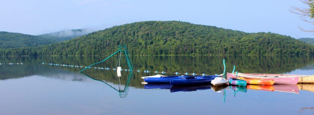 Zone de baignade sur lac Simon avec des canots et des kayaks