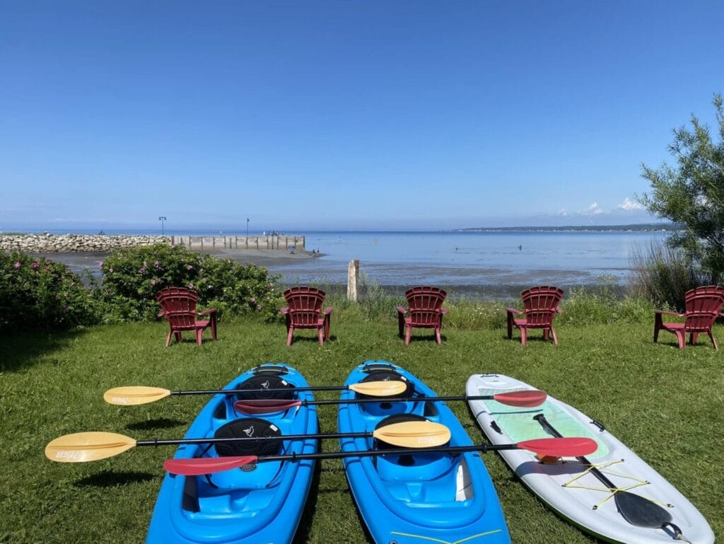 Kayaks et SUP de Plein Air Sainte-Luce avec la baie en arrière-plan.